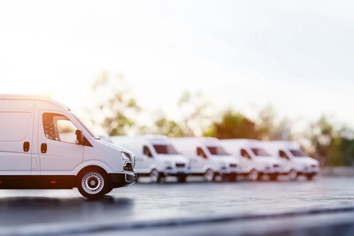 Sell a fleet vehicle in Texas: fleet of delivery vans on a road Fleet of delivery vans on a road, the kind of work vehicles owners sell as a fleet vehicle in Texas