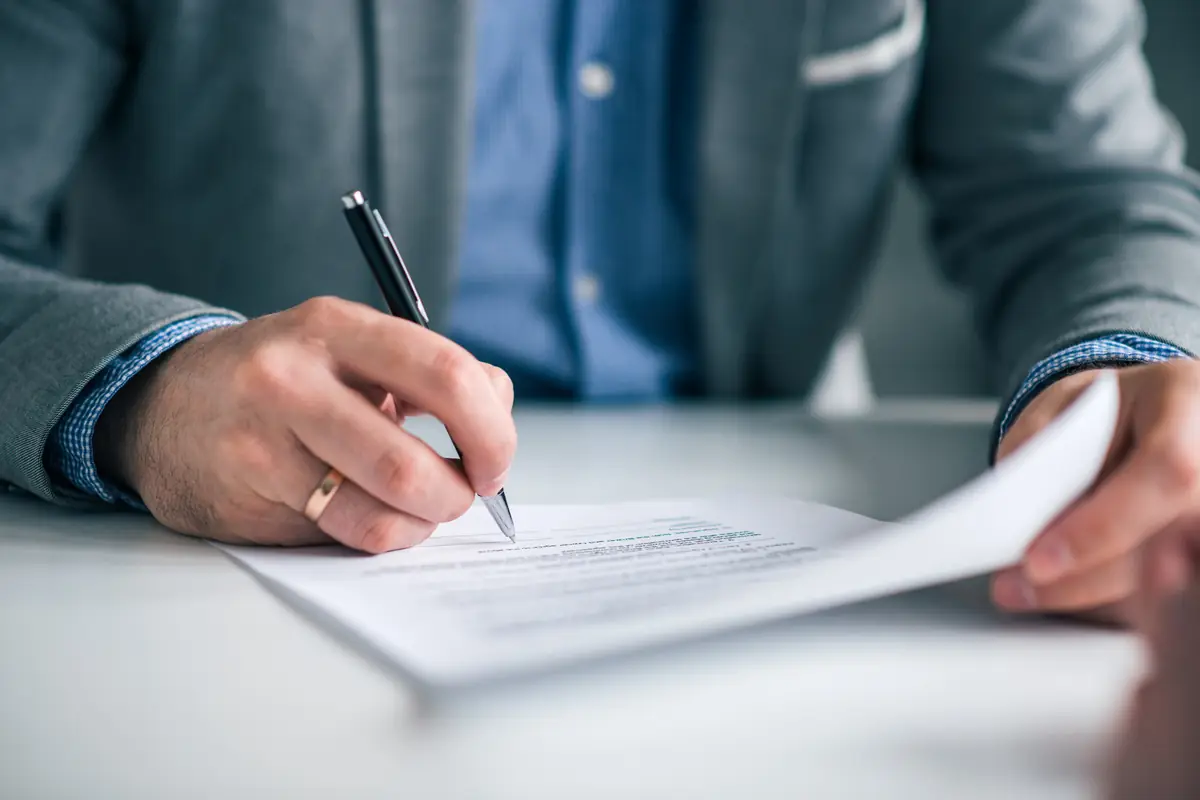 Sell a fleet vehicle in Texas: business owner signing a bill of sale Business owner signing a bill of sale, the paperwork to sell a fleet vehicle in Texas