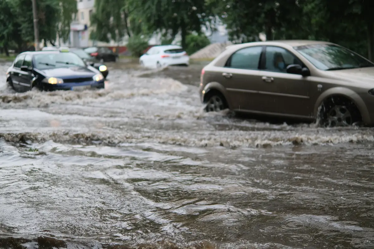Cars driving through a flooded street, how many car insurance flood damage claims begin