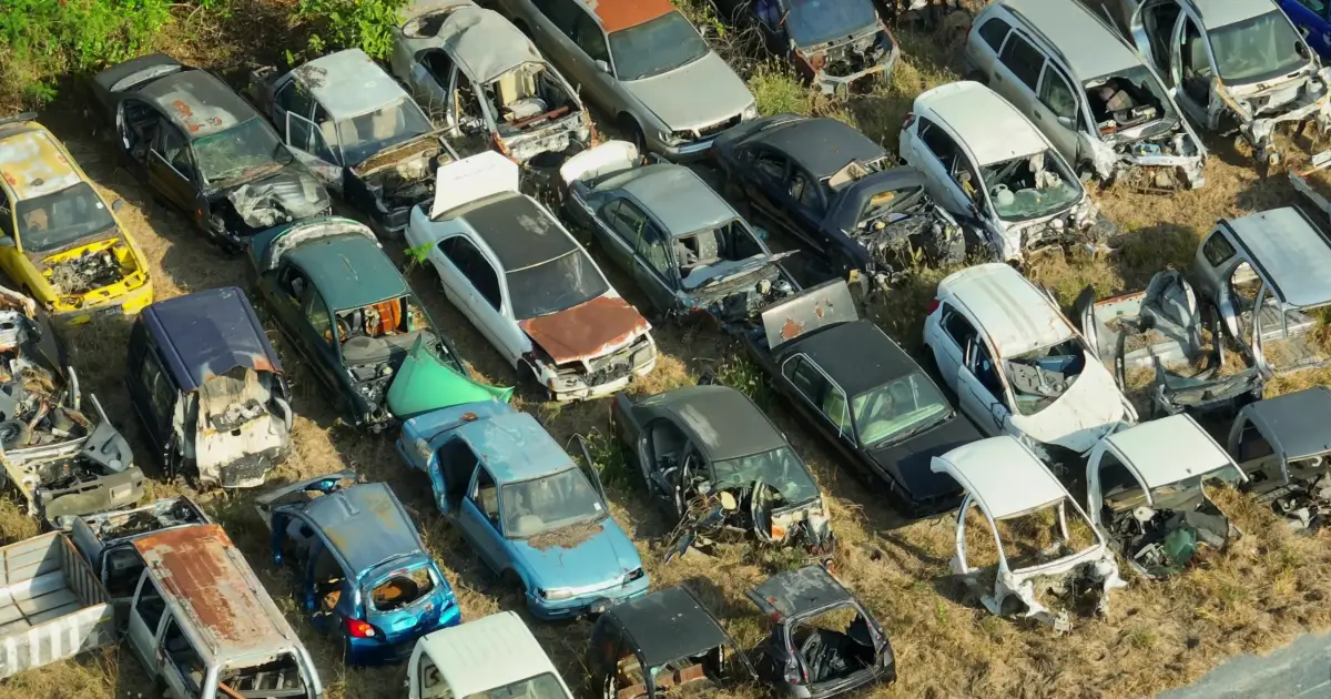 An aerial view of rows of wrecked cars in a junkyard — junk car code enforcement in Texas cities, CashMyCarTX