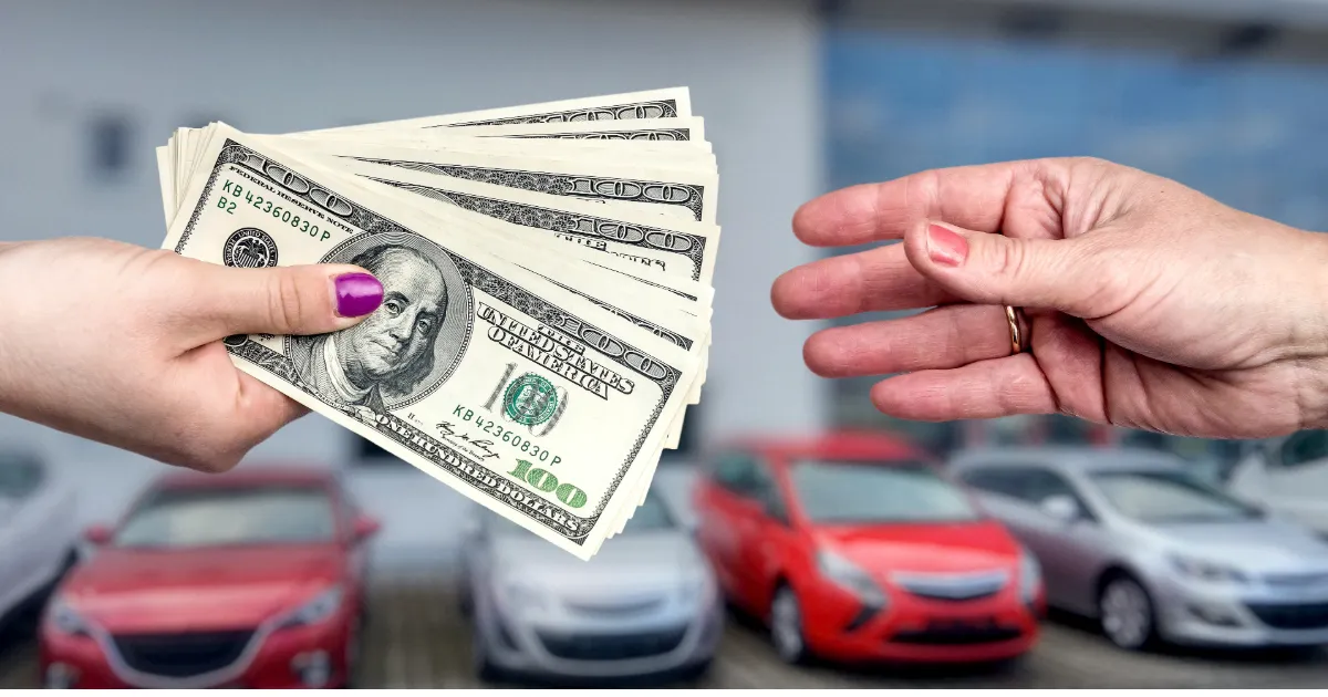 A hand exchanging cash for a car key with parked cars in the background — what ranks for cash for my car searches in Texas