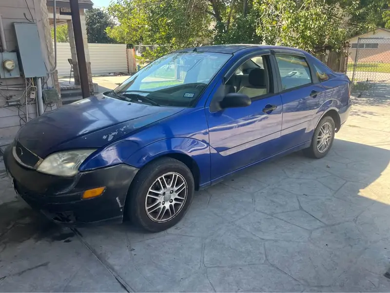 Blue 2006 Ford Focus S junk car bought for $600 in El Paso, TX. Older sedan with worn paint.