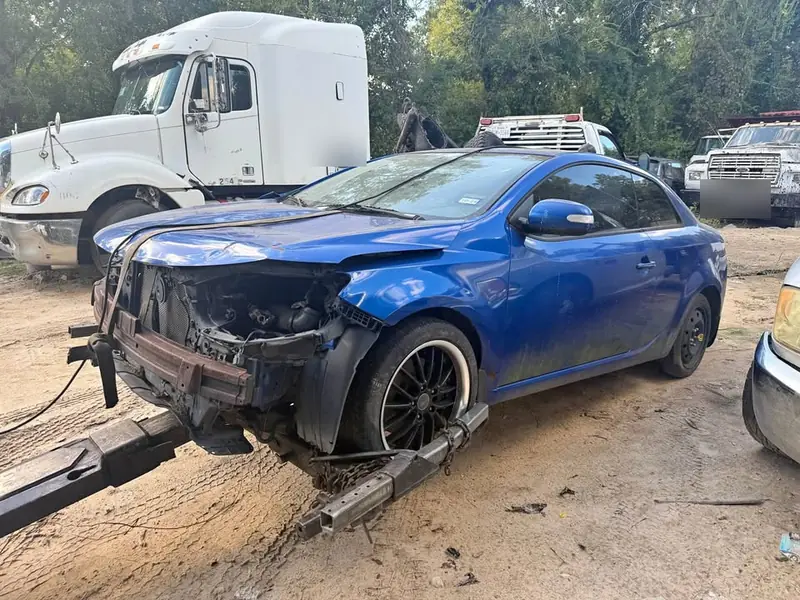Blue 2010 Kia Forte junk car bought for $800 in Midland, TX. Front-end collision damage.